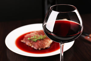 Glass-of-wine-with-grilled-steaj - online wine retailer